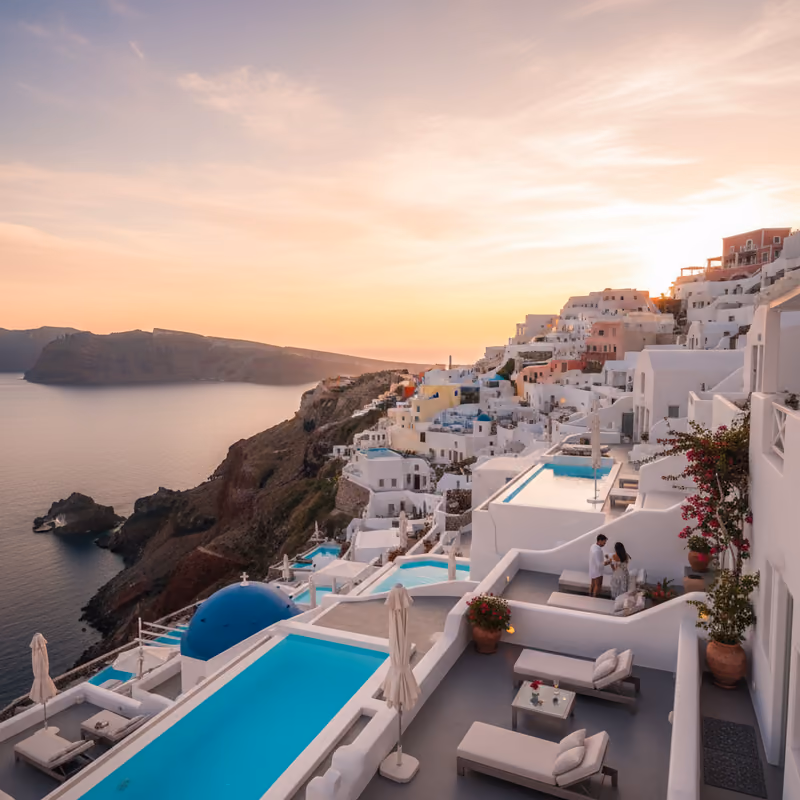 White cliff-top houses above the Aegean at dusk