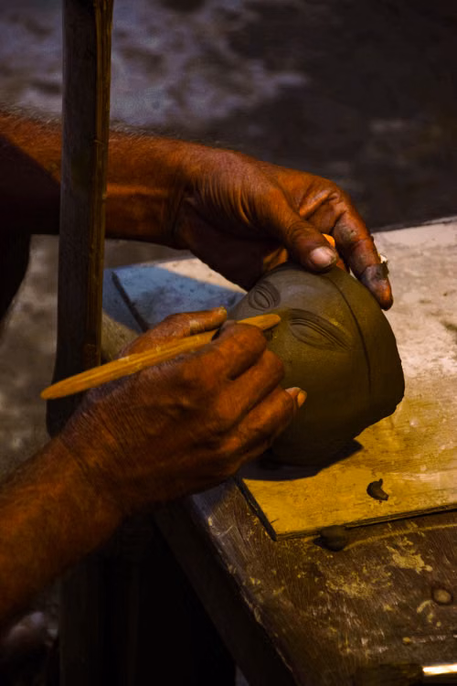 An artisan’s hands decorating a clay pot