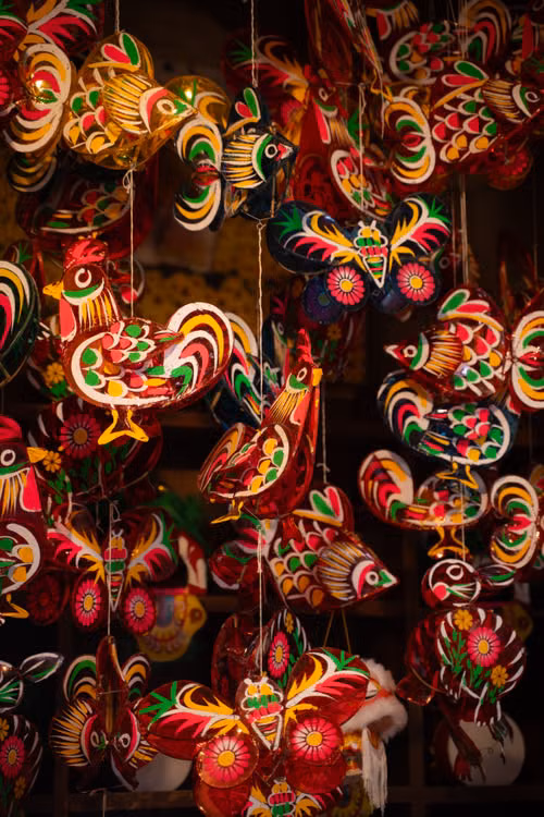 Colourful handmade birds and ornaments hanging in a market