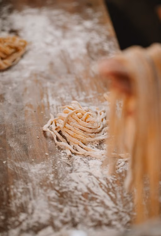 Fresh pasta dough dusted with flour on a wooden board
