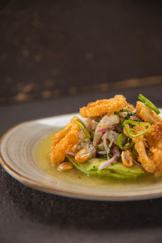 A plate of fried seafood with herbs and sliced chillies