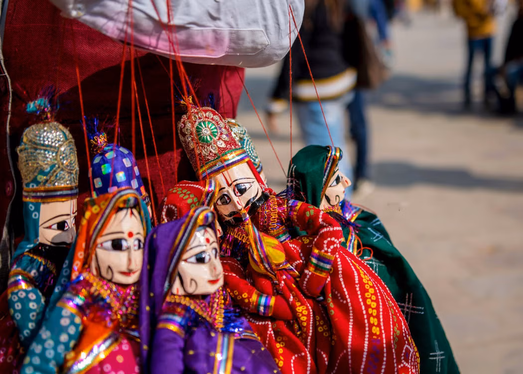 Brightly painted traditional puppets hanging at a market stall