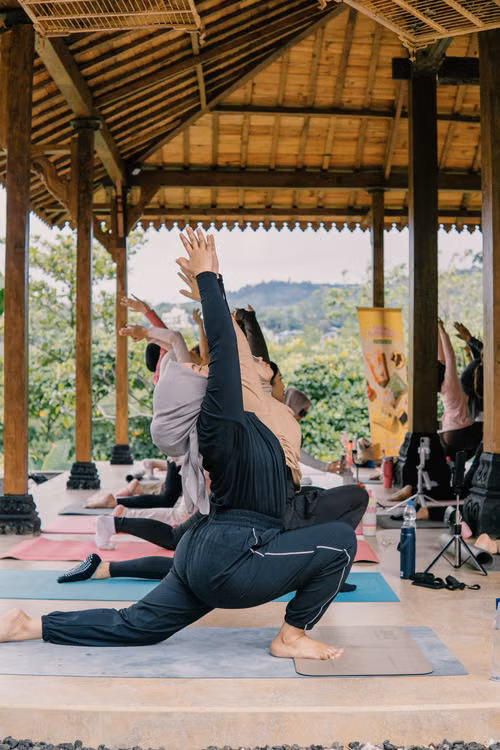 A yoga class practising under an open timber pavilion