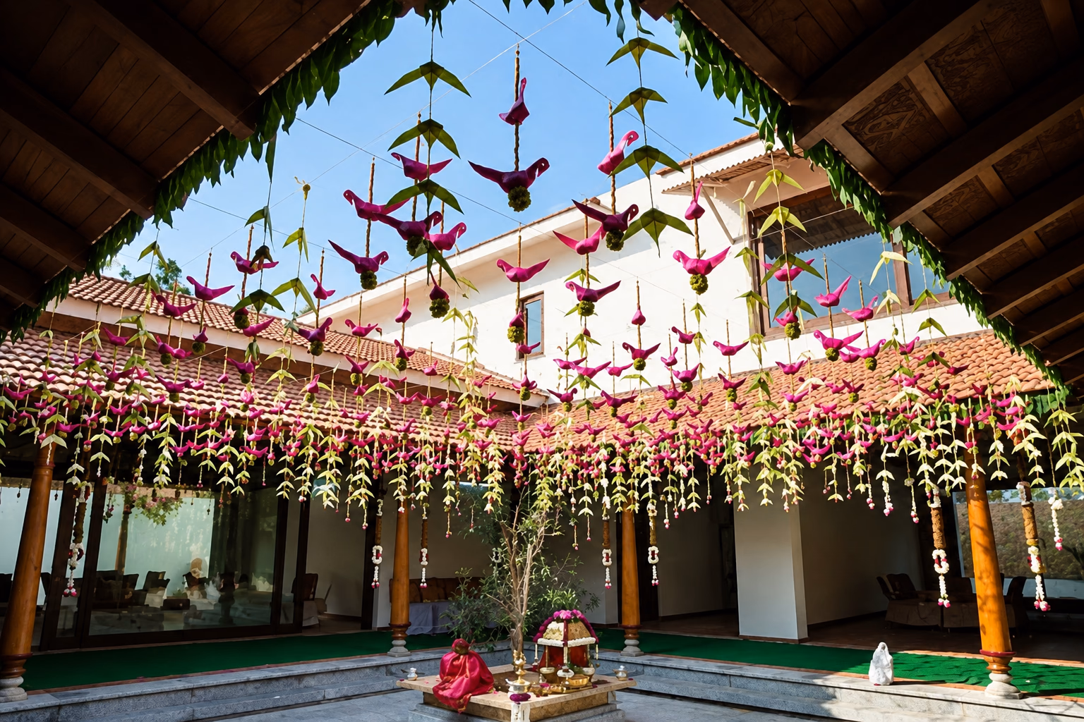 A courtyard hung with strings of paper birds and flower garlands, Chettinad