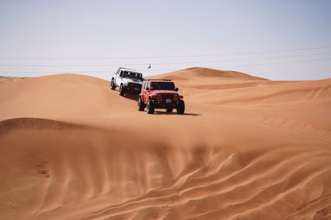Safari vehicles crossing the Dubai dunes