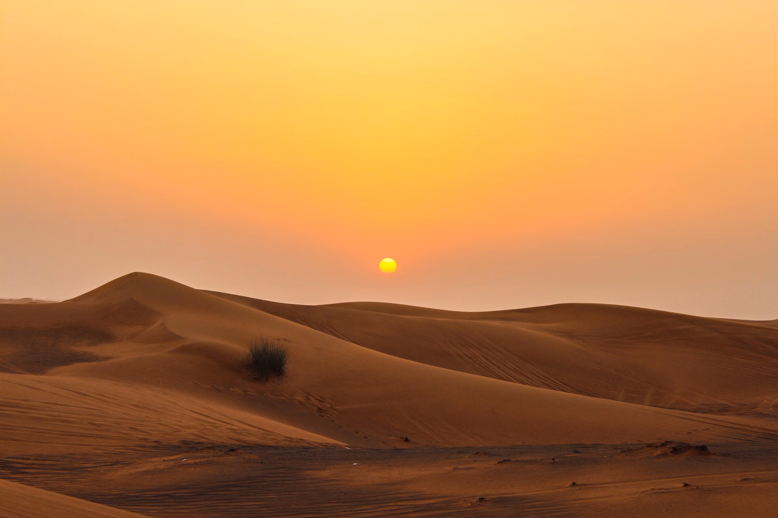 The sun setting over the Dubai desert dunes