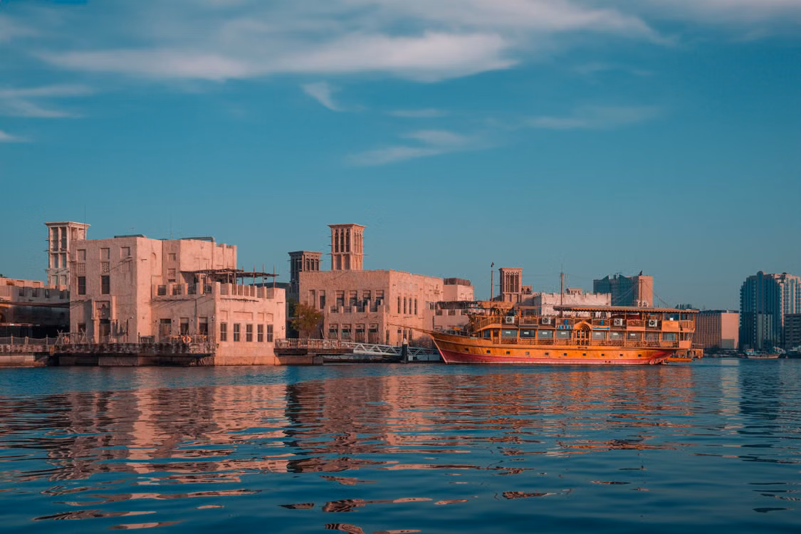 A dhow on the water beside old Dubai