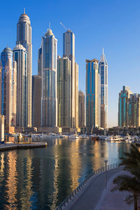 Marina skyscrapers and moored yachts along the waterfront at golden hour
