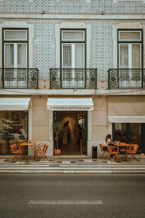 A tiled townhouse front with a café below
