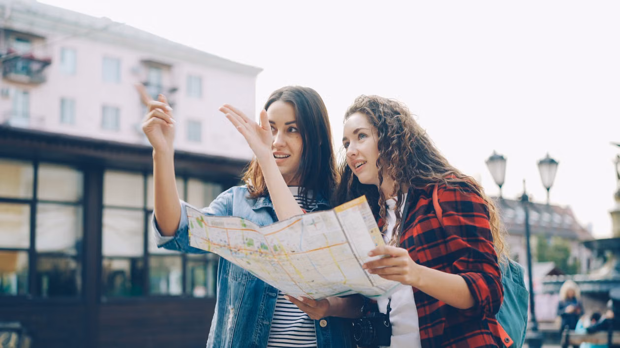 Two women looking at a map together on a city street
